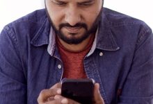 People using smartphones on a busy street in India