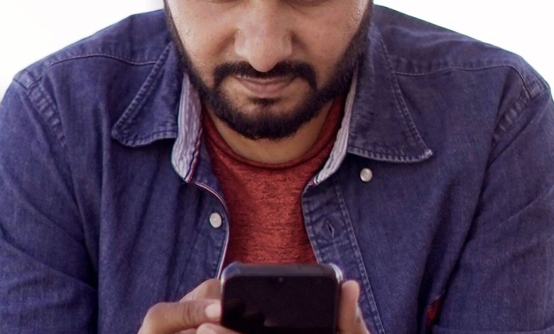 People using smartphones on a busy street in India